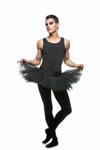 handsome ballet artist in tutu skirt. young man in gymnastics clothes. studio shot. copy space.