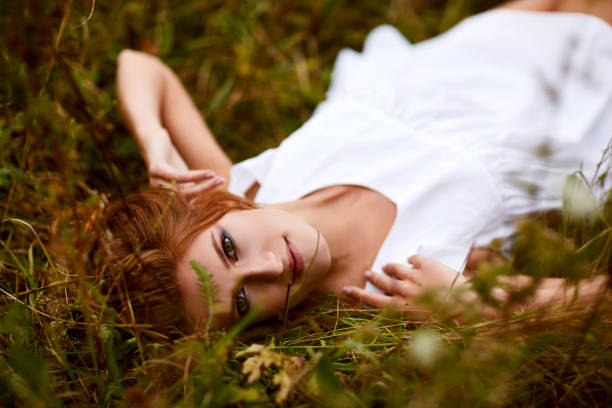 beautiful young woman with red hair in dress in meadow. outdoor shot. copy space.