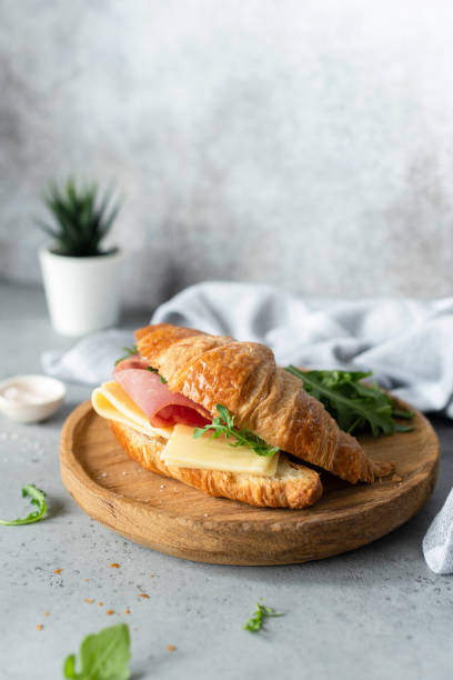 istock Croissant sandwich with cheese, ham and arugula 995329164