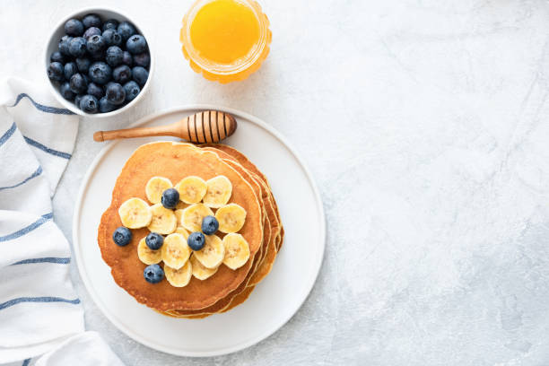 바나나, 블루베리, 콘크리트 바탕에 꿀과 버터 밀크 팬케이크 - pancake ready to eat equipment fruit 뉴스 사진 이미지