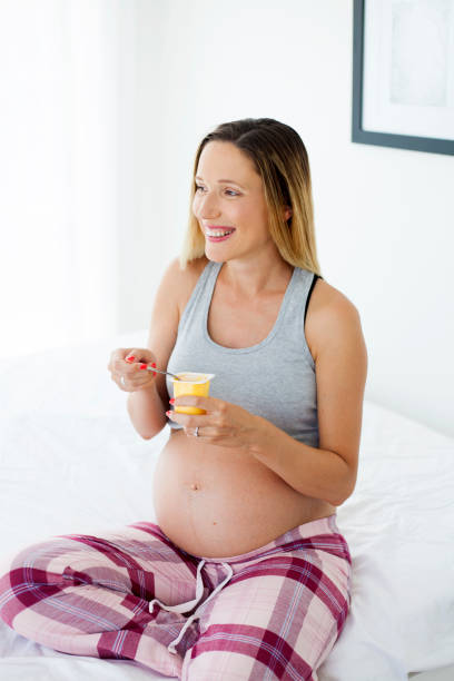 istock pregnant woman eating yogurt 995332124