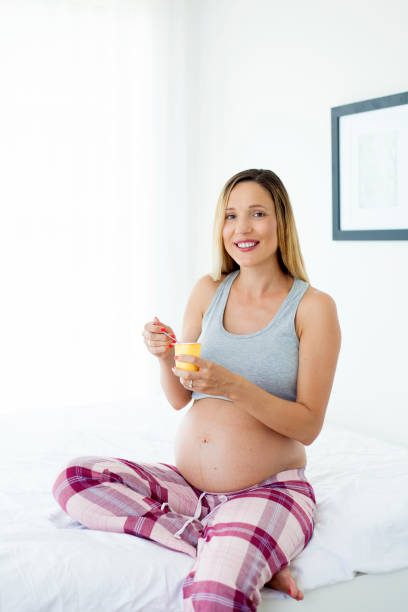 istock pregnant woman eating yogurt 995332728