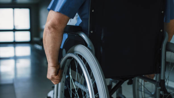 廊下を車椅子移動で老人病院で次のクローズ アップ ショットします。 - working people physical impairment wheelchair ストックフォトと画像