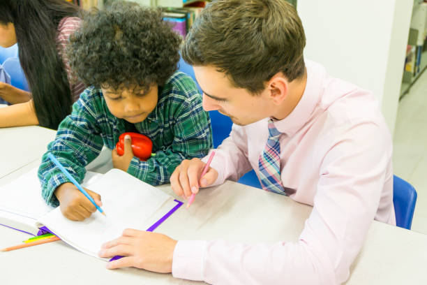 istock man teacher and kid student learn with book at bookshelf background 995343292