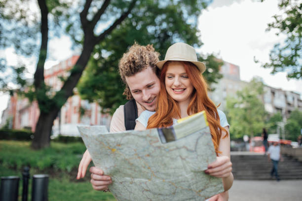 istock Young man hugging a woman who is holding a map in her hands 995343654