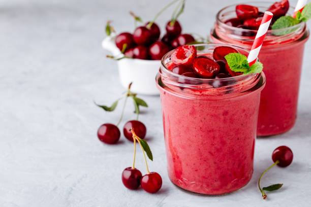 Cherry smoothie in glass with mint leaves and fresh berries Cherry smoothie in glass jars with mint leaves and fresh berries cherry stock pictures, royalty-free photos & images