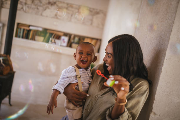 istock Mother and little son having fun blowing bubbles at home 995369450
