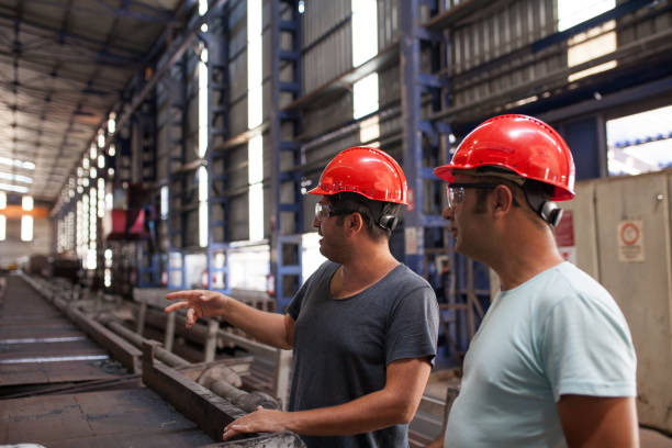 istock Two engineers in hardhats  in a factory. 995378144