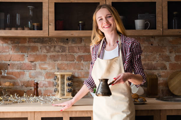 istock woman apron making coffee morning home kitchen 995381706