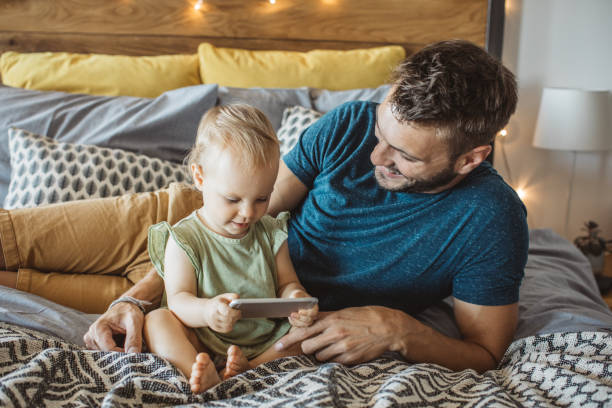 istock Father shows little daughter something on phone 995382096
