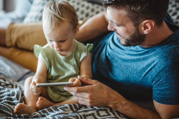 istock Father shows little daughter something on phone 995382244
