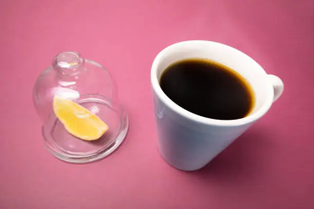 Mug of hot coffee and lemon. The concept of taste and coffee mood.