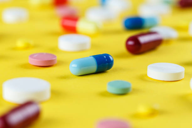 istock different pills and capsules scattered on a yellow background 995402694