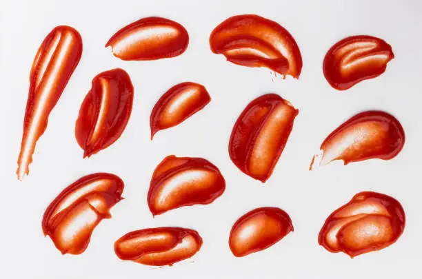 Ketchup stains and splashes isolated on white background, top view