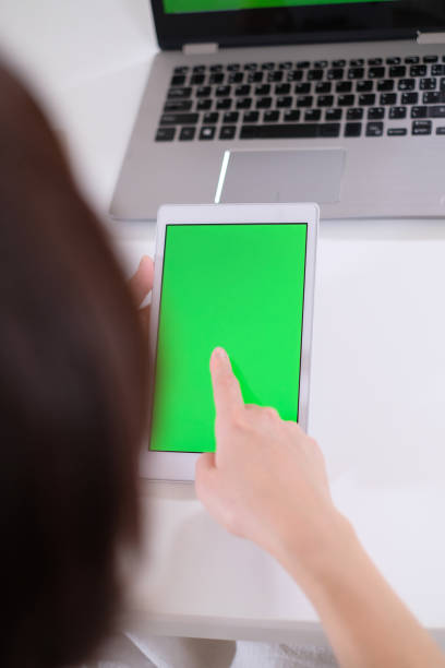 istock green screen of tablet PC in hands 995416124