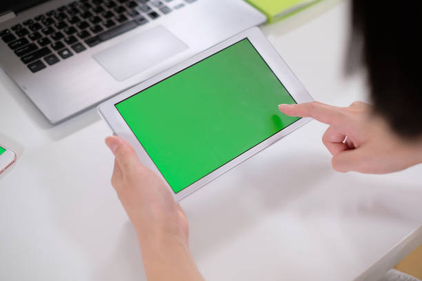 istock green screen of tablet PC in hands 995416236