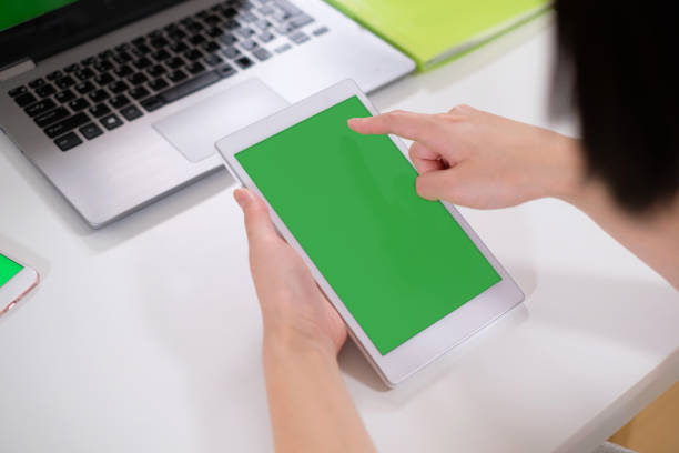 istock green screen of tablet PC in hands 995416286