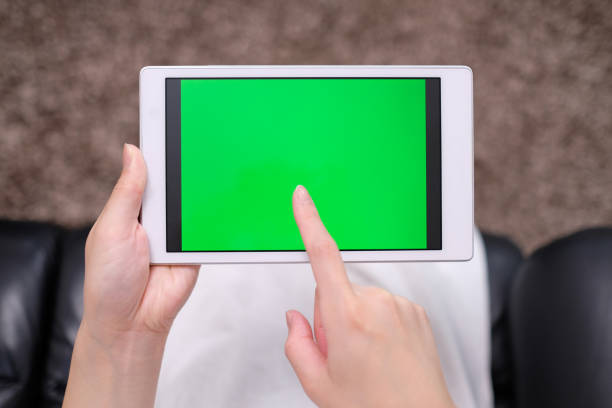 istock woman's POV of green screen of tablet PC 995420368