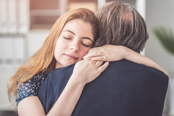istock Young daughter hugs her father 995421278