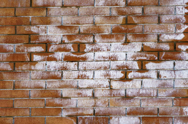 istock Cracked vintage brick wall background half covered with salt 995433114