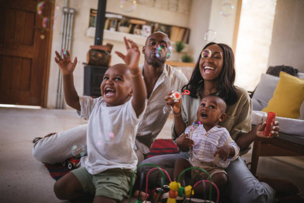 familien mit kleinen kindern spaß sprudelt wehen zu hause - african ethnicity brother ethnic little boys stock-fotos und bilder