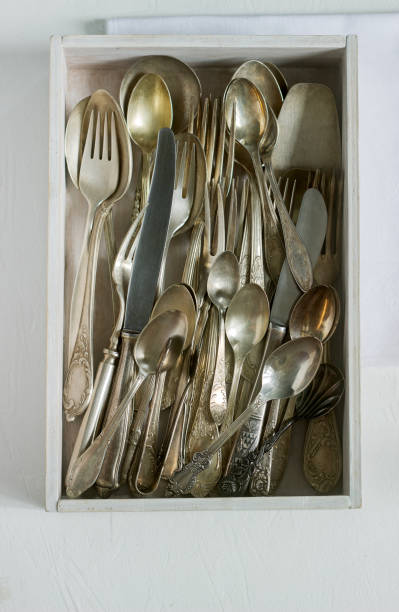 istock Vintage silver cutlery in a white wooden box on a white table. Rustic style. 995443732