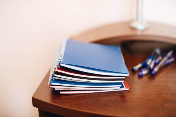 istock Close-Up Of Spiral Notebooks On Wooden Table 995444162