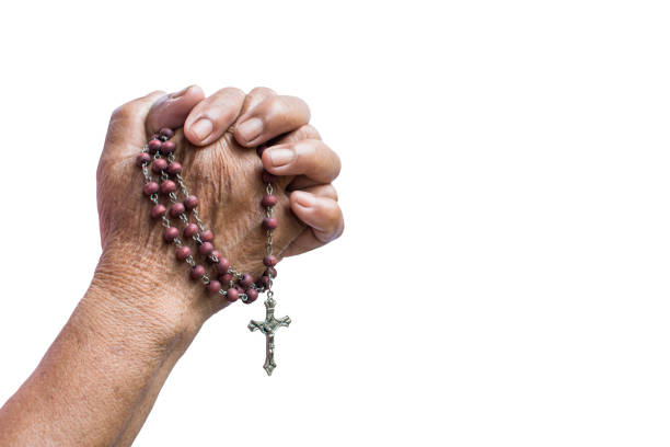 Hands folded and there is a cross in prayer on a Holy Bible in church concept for faith, spirtuality and religion