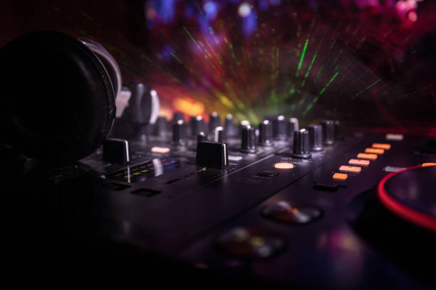 istock In selective focus of Pro dj controller.The DJ console deejay mixing desk at music party in nightclub with colored disco lights. 995459780