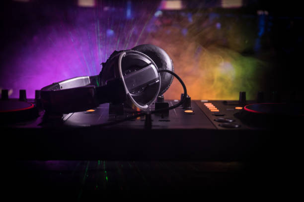 istock In selective focus of Pro dj controller.The DJ console deejay mixing desk at music party in nightclub with colored disco lights. 995459788