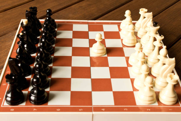 istock Black and white chess on a chessboard on a wooden table. Chess game concept 995464826