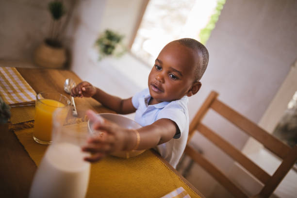 istock Boy having breakfast with cereal, milk and fresh orange juice 995465132