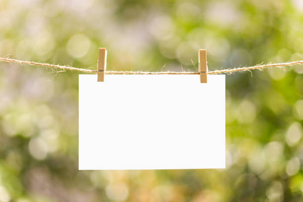 istock Blank message card on clothespins isolated on green 995501550