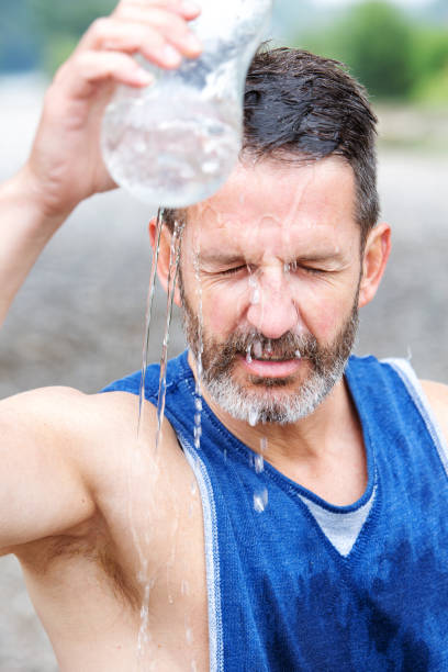 istock athlete standing outdoors and pouring water on himself 995513442