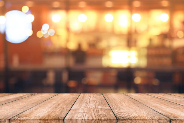 istock Empty wood table top with blurred light bokeh in night cafe restaurant background 995518252