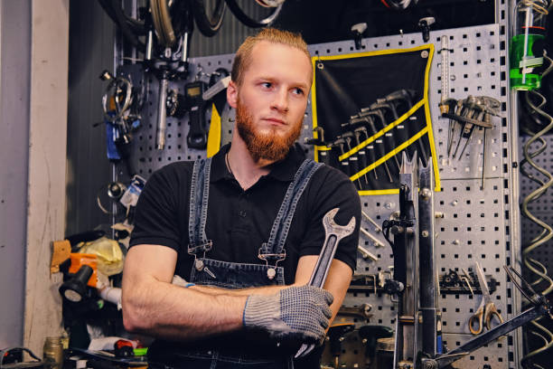 istock Biicycle mechanic with crossed arms holds cup key over. 995518278