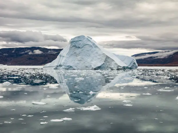 Giant Arctic Iceberg reflecting in the calm Arctic Ocean Waters. Disko Bay, Ilulissat, Western Greenland. Hasselblad 50 MPixel XXXL Shot.