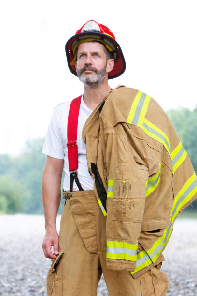 istock handsome fireman in uniform standing outdoors 995528766