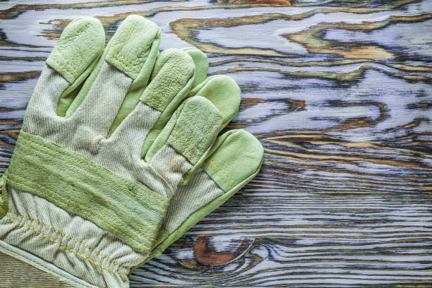 istock Safety gloves on wooden board horizontal image 995529956