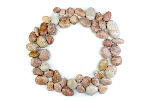 Round frame of small sea stones, isolated on white. Top view with copy space