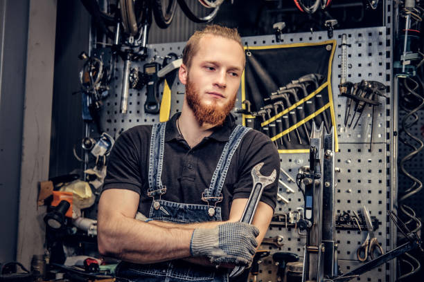 istock Biicycle mechanic with crossed arms holds cup key over. 995538736
