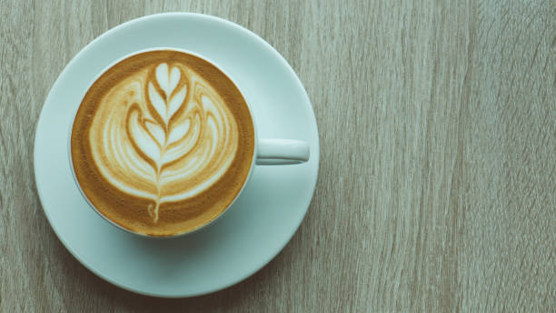 istock latte coffee cup on wood table 995553060