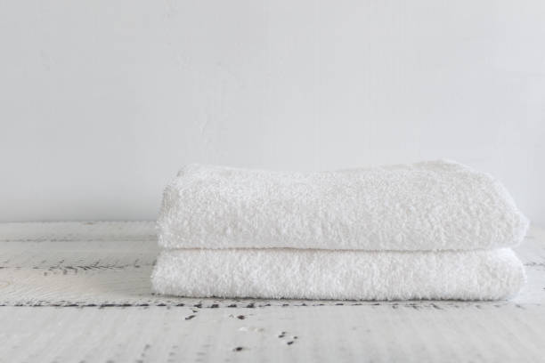 istock Folded two white towels on a white wooden table. Spa and wellness, cotton terry textile. Ecological theme 995553102