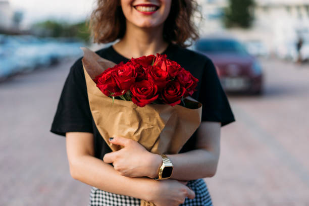 mujer joven con ramo de hermosas flores rojas - valentine present fotografías e imágenes de stock