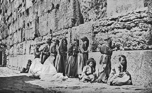 Jewish people at the Western Wall in Jerusalem, Israel. Vintage halftone photo etching circa late 19th century.