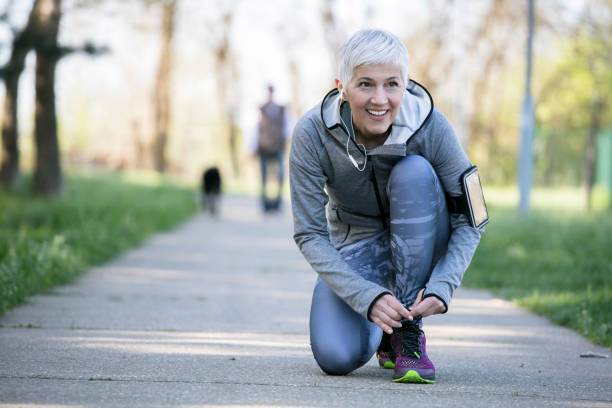 piękna kobieta z siwymi włosami na początku lat sześćdziesiątych relaks po treningu sportowym - exercising running jogging healthy lifestyle zdjęcia i obrazy z banku zdjęć