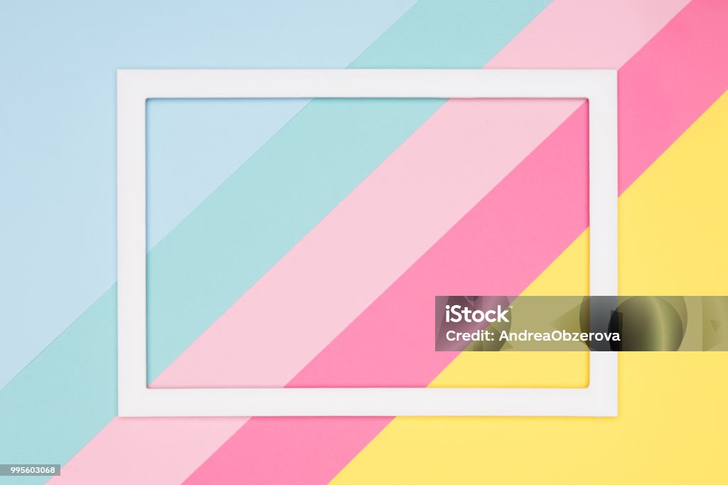 Abstract geometrical pastel blue, pink and yellow paper flat lay background. Minimalism, geometry and symmetry template with empty picture frame mock up. Candy Stock Photo