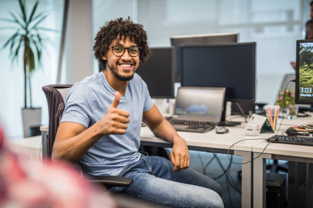 Happy African American programmer showing thumbs up in the office.