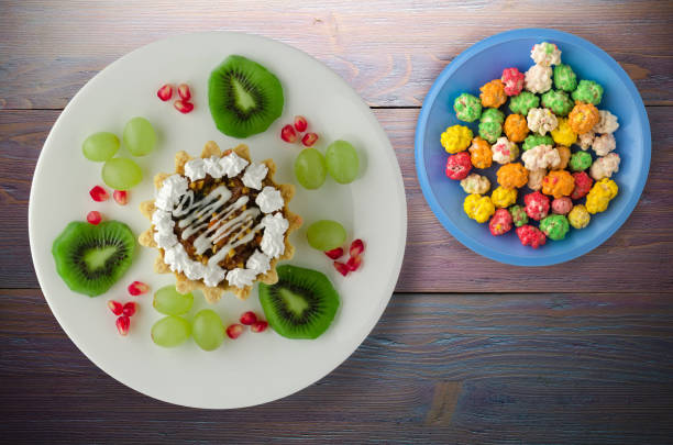 istock dessert of cake and fruit (grapes, kiwi, pomegranate) on a wooden 995609154