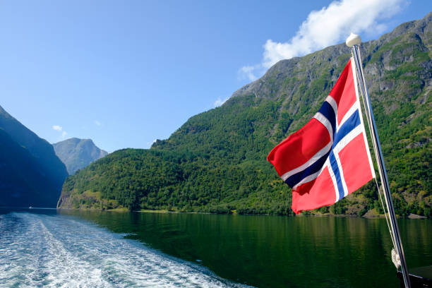 istock Norwegian flag flying with fjord in background 995633182